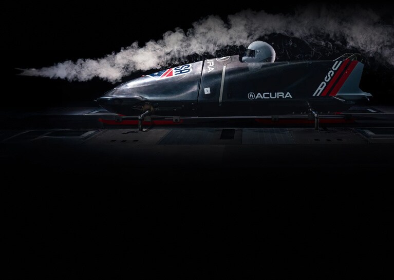 Acura USA bobsled in profile view undergoing wind tunnel testing with smoke stream. Acura USA bobsled in profile view undergoing wind tunnel testing with smoke stream.