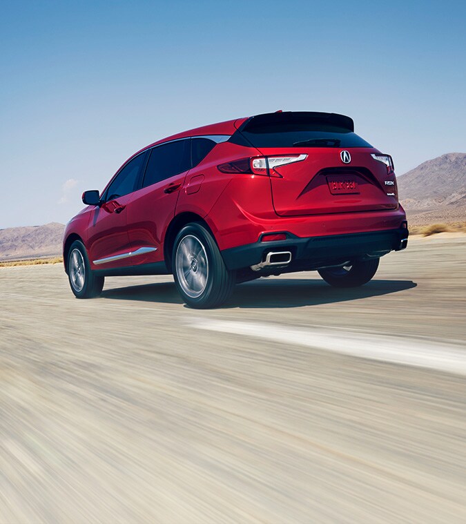 2022 RDX in Performance Red Pearl driving in a highway 3/4 rear view