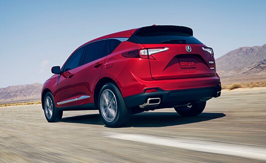 2022 RDX in Performance Red Pearl driving in a highway 3/4 rear view
