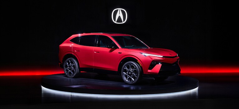 2026 Acura Hybrid 7/8 front on a dark studio stage with red lighting accents. 2026 Acura Hybrid 7/8 front on a dark studio stage with red lighting accents.