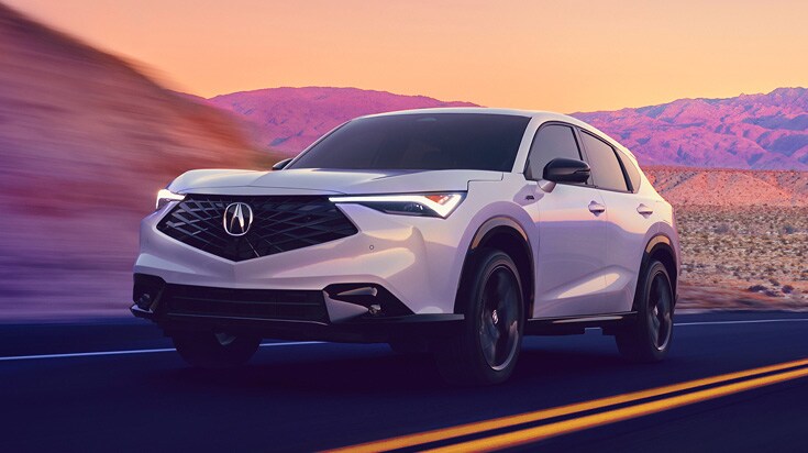 2026 Acura ADX A-Spec with Advance Package in Platinum White Pearl, front view, driving on a desert road at sunset (Premium Compact SUV).