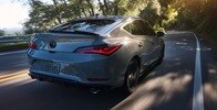 2026 Acura Integra car in Urban Gray Pearl driving on the road.