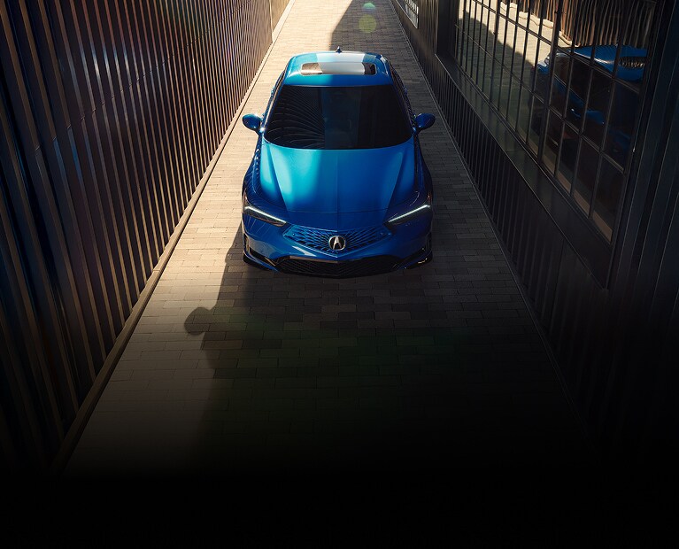 2026 Acura Integra A-Spec with Technology Package in Double Apex Blue Pearl top parked in an alleyway (Premium Sport Compact).