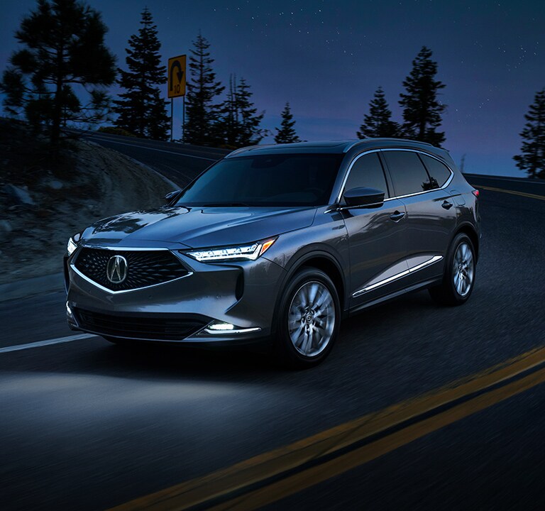2022 Acura MDX Advance in Liquid Carbon Metallic driving at night 