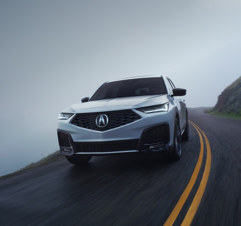 2026 Acura MDX Advance Package in Platinum White Pearl driving on road