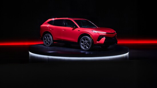2026 Acura Hybrid 7/8 front on a dark studio stage with red lighting accents.